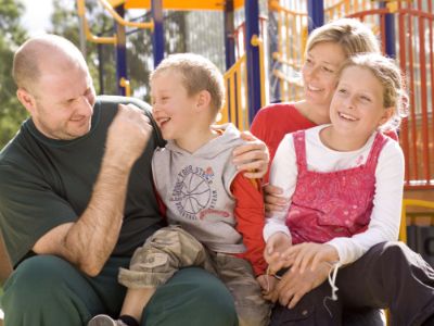 Family laughing together outdoors, representing support and connection.